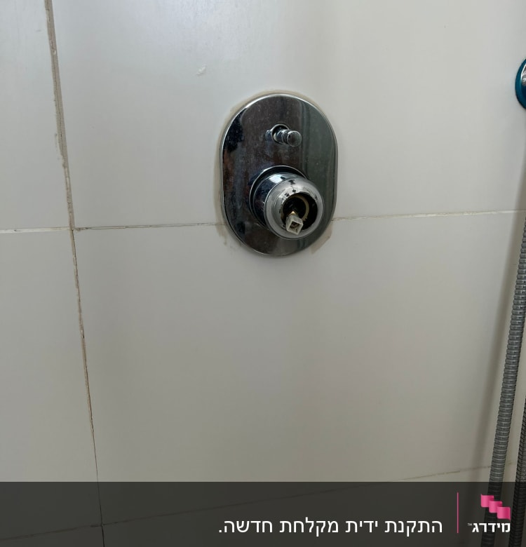 ברז מים מקולקל על קיר אריחים לבן
